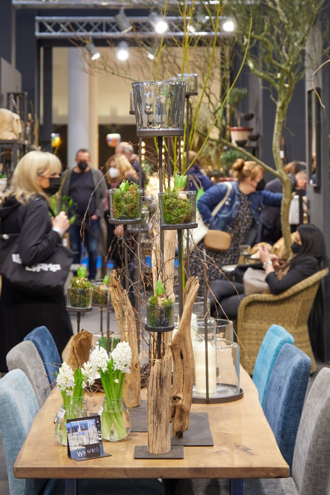 A wooden table, decorated with several glass vases and spring flowers