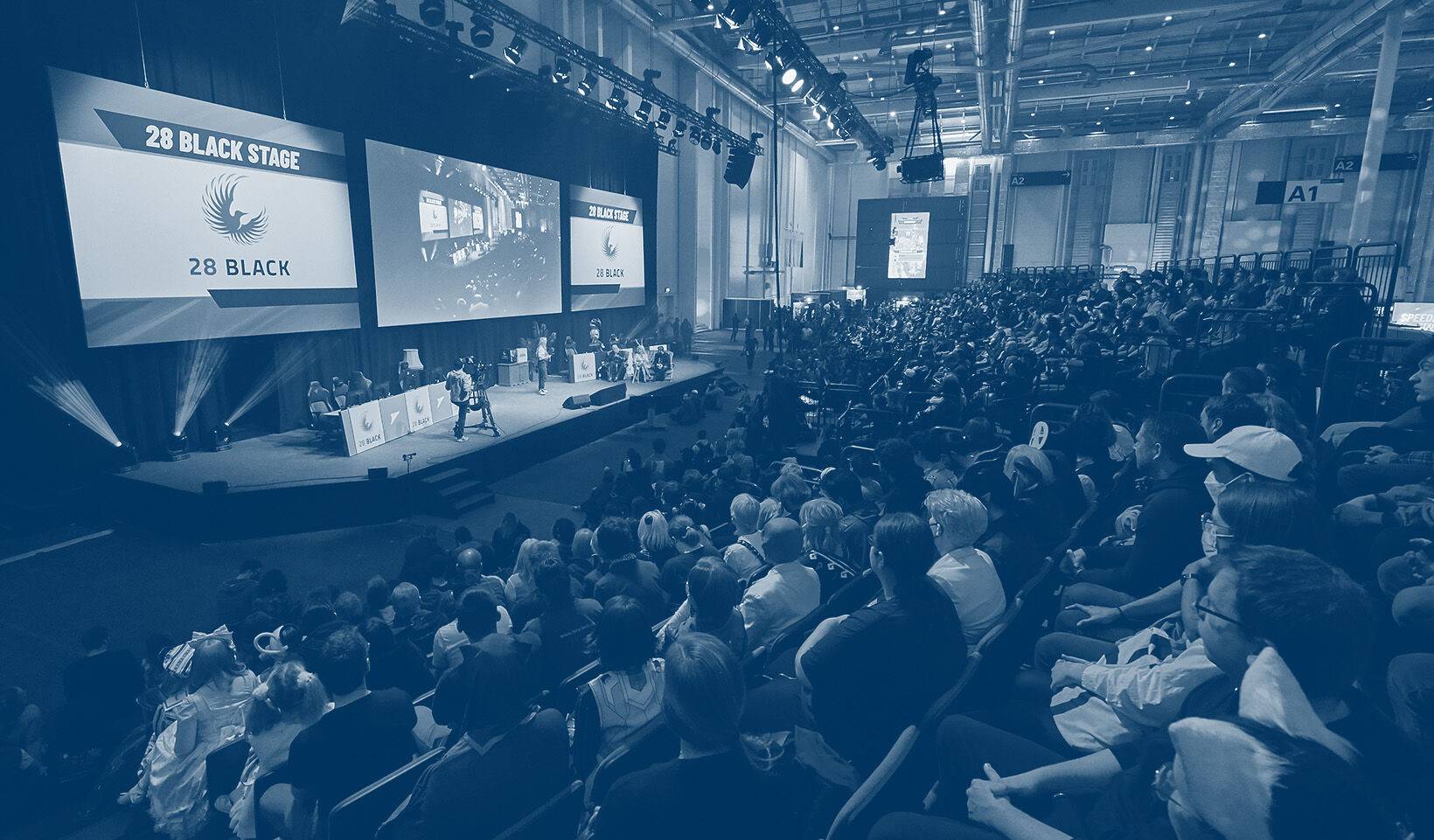People on grandstands, looking towards the stage at the POLARIS Convention 2022