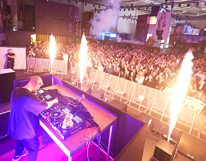 A DJ at PHOTOPIA 2022, looking at the celebrating guests