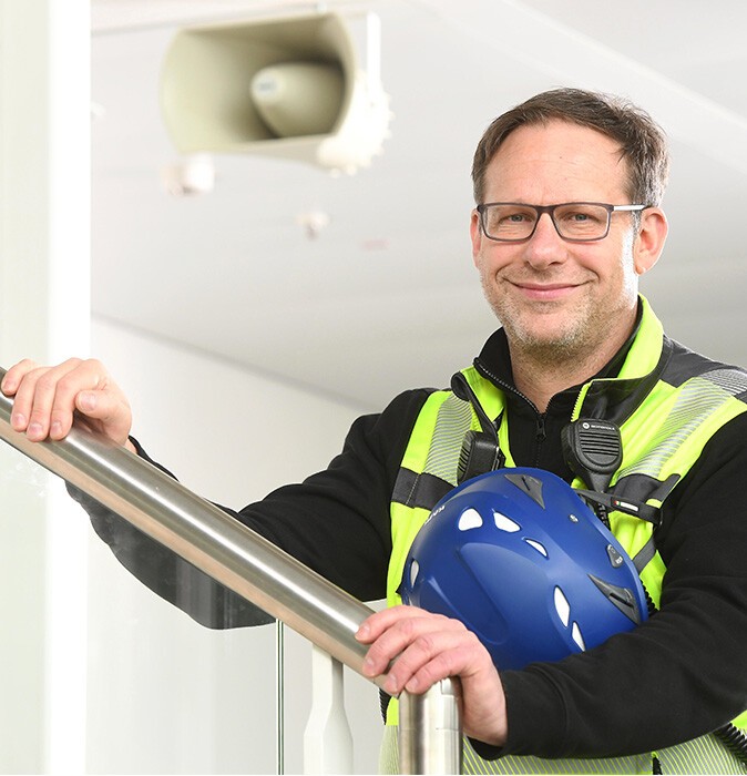 Portrait of Florian Röner with loudspeaker in the background
