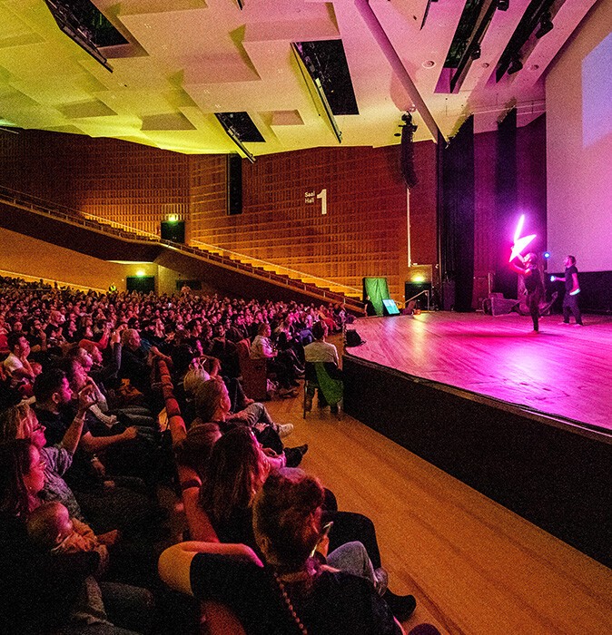 Guests of the youth festival of the German Hearing-Impaired Youth seated in the CCH, looking at the stage