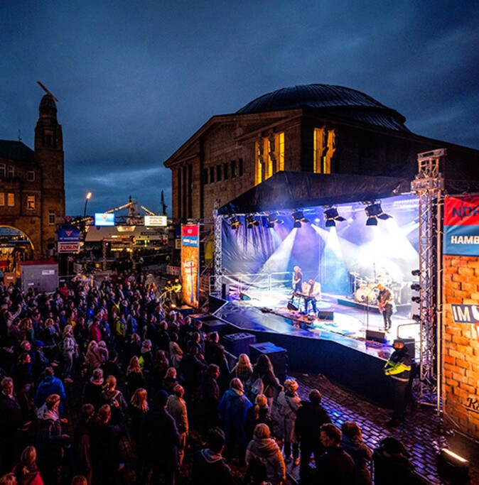 A show stage on the Landungsbrücken Piers after sundown during the Port Anniversary