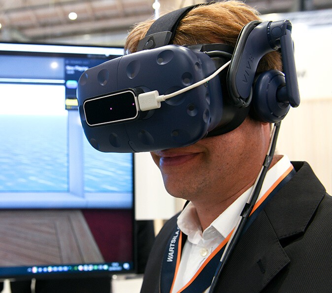 A visitor wearing VR goggles at SMM 2022
