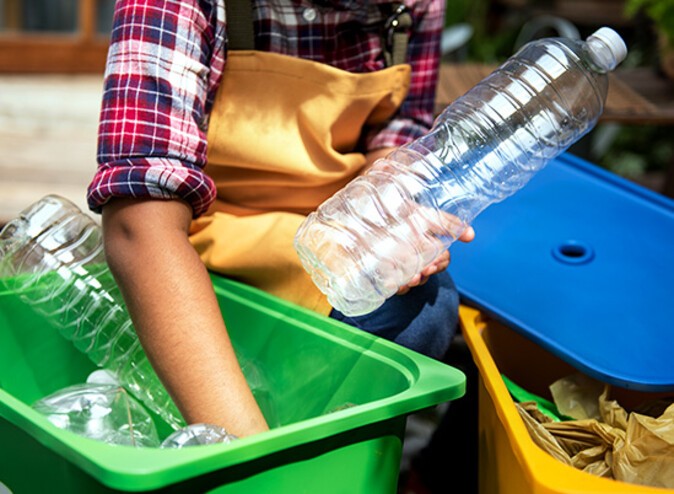 Plastic bottles are being taken out of a rubbish bin