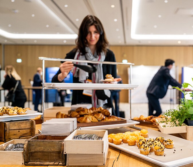 A lady serving herself food at a buffet 