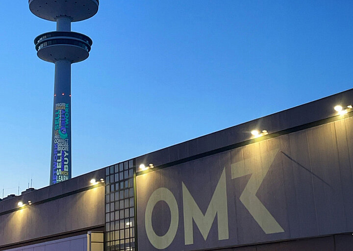 Façade with OMR lettering and television tower in the background
