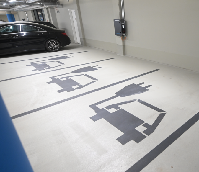 Parking spaces designated to electric cars by a sign painted on the ground