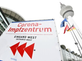 Sign indicating the direction to the Corona vaccination center in front of the exhibition